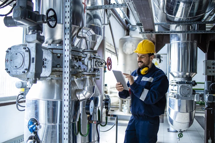 Technicien utilisant une tablette dans une installation industrielle