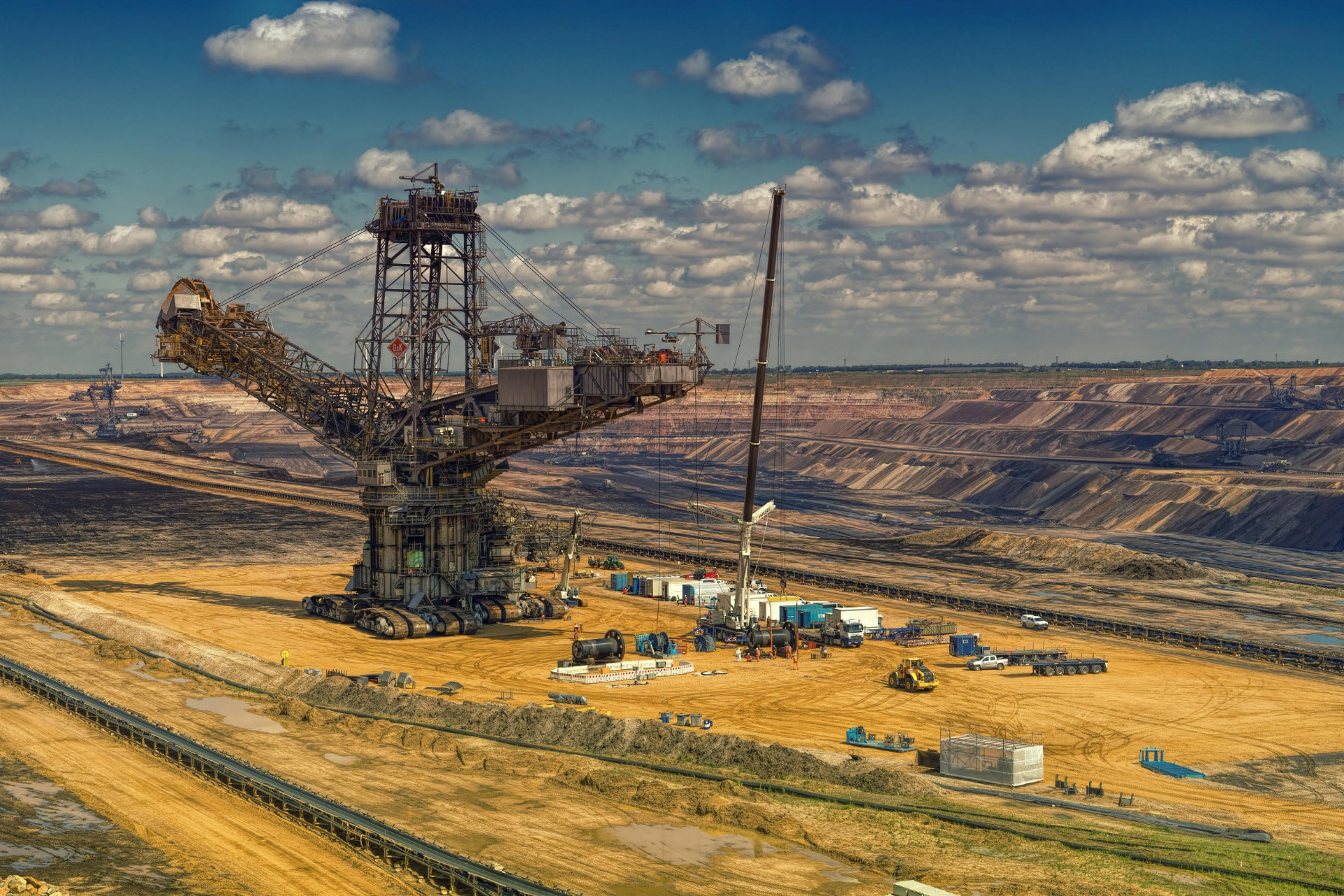 Site industriel à grande échelle avec engins de terrassement et convoyeurs